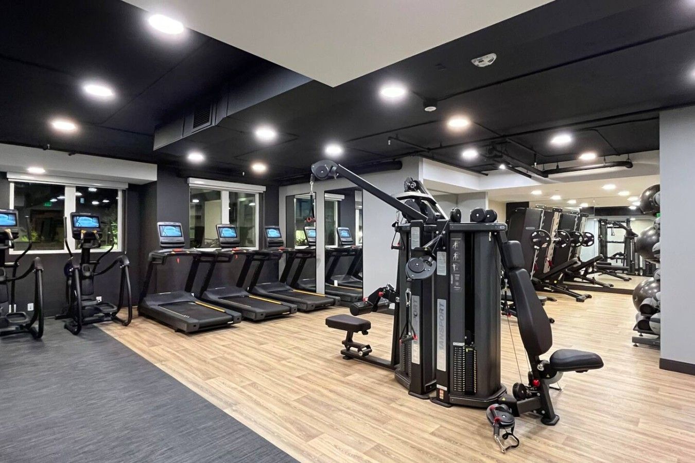 A gym with treadmills, weight machines, and exercise equipment.
