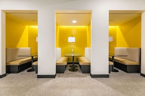 A modern interior with a central table and seating area, surrounded by walls with a yellow accent. - Lux Living 3BD 3BTH in K-Town, Pool, Gym & Parking (Los Angeles)