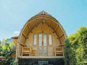 A wooden building with a gabled roof, large windows, and a stone base.