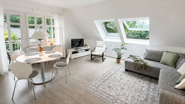 A modern living room with a dining area, a sofa, a TV, and a large window. - Emsblick & Naturglück – Auszeit in Fresenburg (Fresenburg)