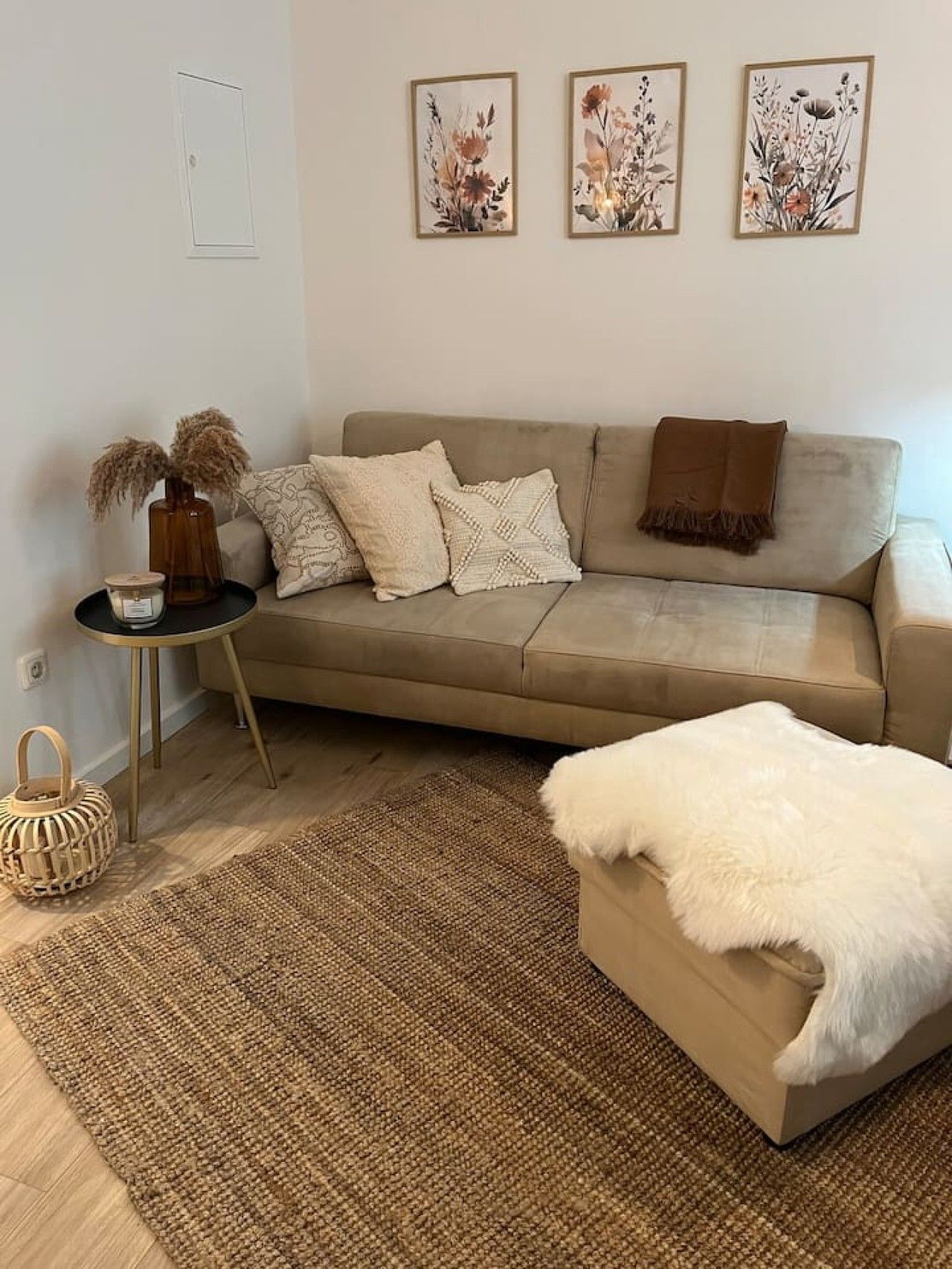 Ein modernes Wohnzimmer mit einer Couch, einem Beistelltisch, einem Teppich und Wandbildern.