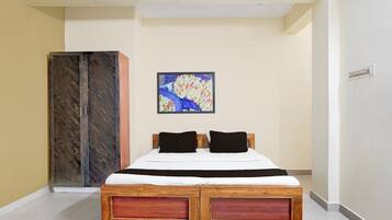 A bedroom with a bed, a wardrobe, and a painting on the wall.