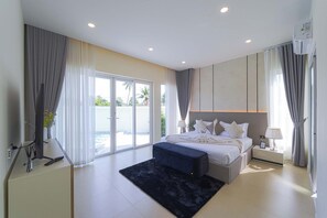A modern bedroom with a large bed, a flat-screen TV, and a sliding glass door leading to a pool area. - 3BR Luxury Pool Villa, Hua Hin (TP3) (Hua Hin)