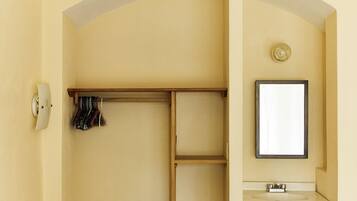 Un dormitorio con cama, armario, espejo y lavabo.