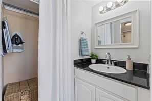 A bathroom with a white sink, a mirror, and a towel rack. - Newly Renovated Waikiki Studio #801 • Balcony • 3P (Honolulu)