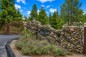 A stone wall with a sign reading 'Slide Creek Estates' and a gated entrance.