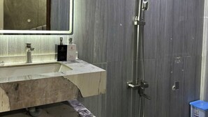 A modern bathroom with a marble sink, a large mirror, and a shower. - Cherysh House TTT (Ben Thanh)