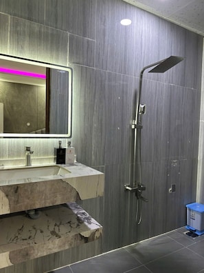 A modern bathroom with a marble sink, a large mirror, and a shower. - Cherysh House TTT (Ben Thanh)