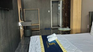 A modern hotel room with a bed, a desk, a mirror, and a wardrobe. - Cherysh House TTT (Ben Thanh)