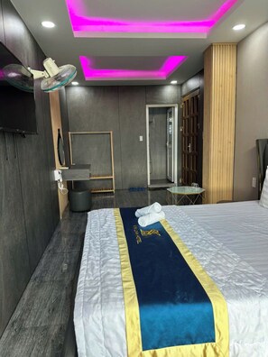 A modern hotel room with a bed, a desk, a mirror, and a wardrobe. - Cherysh House TTT (Ben Thanh)