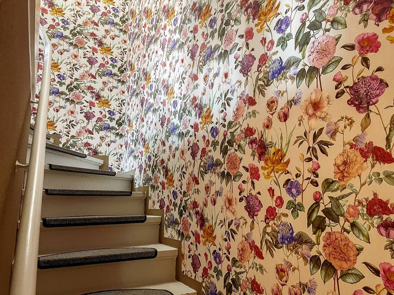 A staircase with a floral wallpaper design.