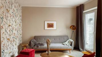 A living room with a sofa, a coffee table, and a floor lamp.