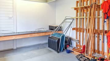 A room with a wooden workbench, a suitcase, and various tools.