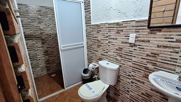 Un baño con inodoro, bidé y lavamanos.