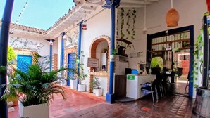 Una hall d'albergo con pavimento piastrellato, una reception e un arco in mattoni.