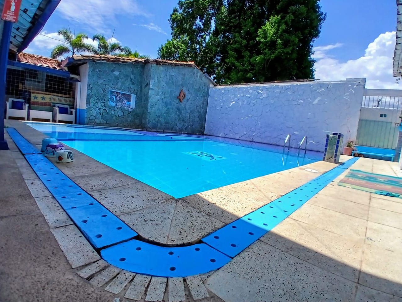 A swimming pool with a tiled deck and a blue safety border.