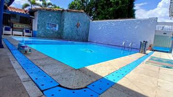 A swimming pool with a tiled deck and a blue safety border.