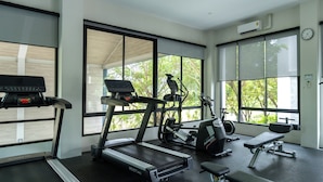 Una palestra con tapis roulant, ellittiche e una panca.