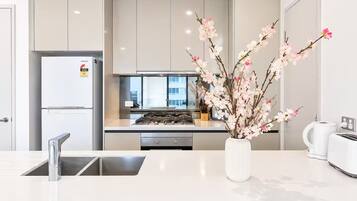 A modern kitchen with a built-in stove, a refrigerator, and a sink.
