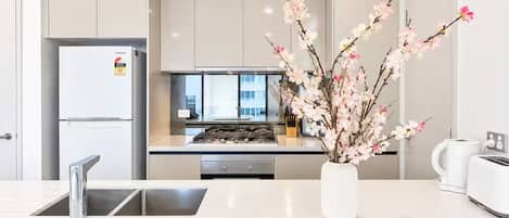 Una cocina moderna con estufa integrada, refrigerador y pileta.
