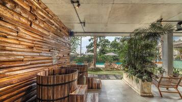 Una pared de troncos de madera, un barril de madera y una zona de estar con sillas y una mesa.