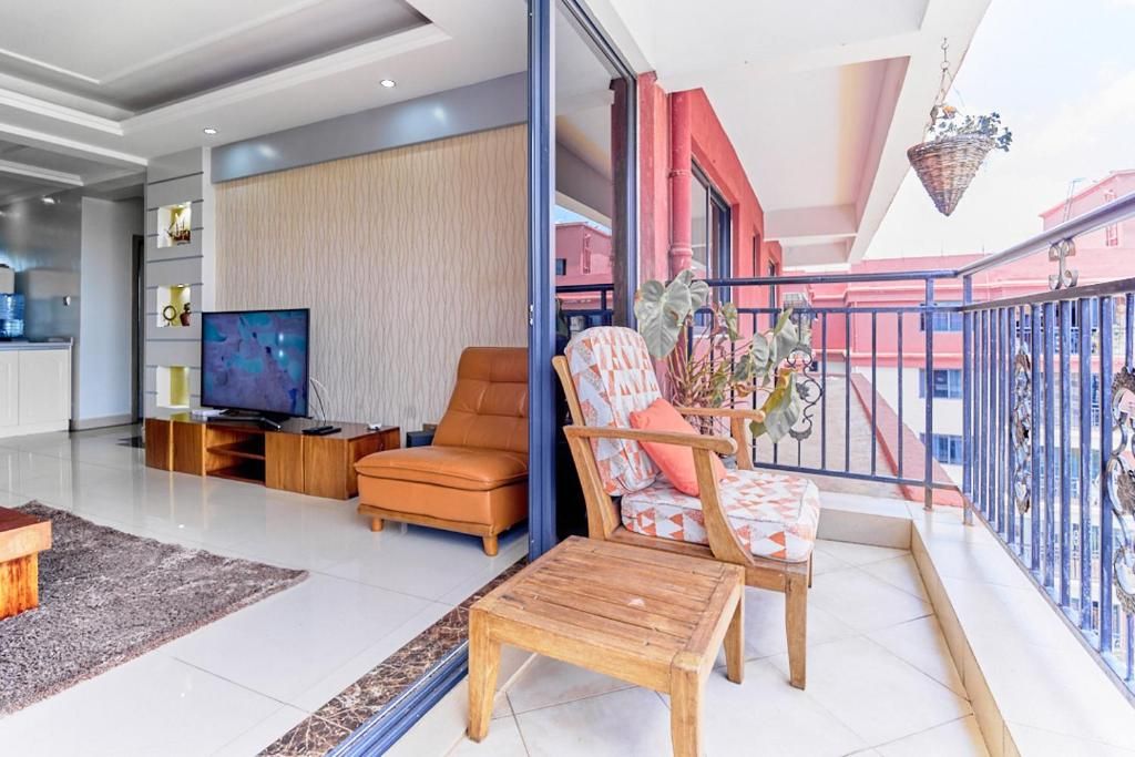 Una sala de estar moderna con televisor de pantalla plana, sofá de cuero y mesa de centro de madera.