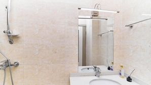 A bathroom with a sink, mirror, and shower. - Crestpark Skyline Penthouse (Nairobi)