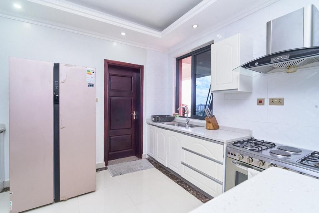 Una cocina moderna con armarios blancos, una estufa a gas y un refrigerador.