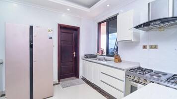 Una cocina moderna con armarios blancos, una estufa a gas y un refrigerador.