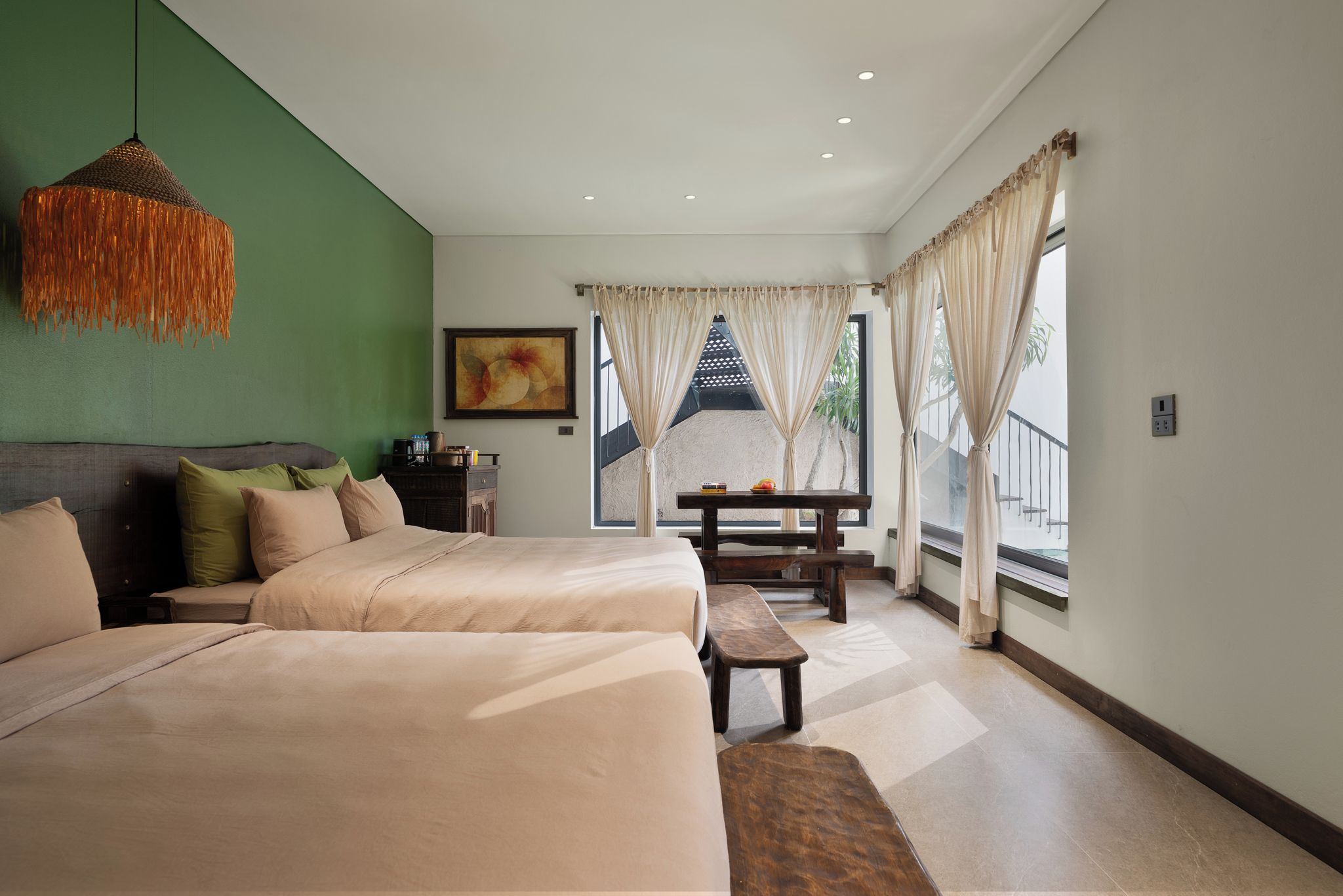 A bedroom with two beds, a dining table, and a view of the outdoors.