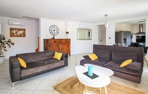 A modern living room with two sofas, a coffee table, a world map, and a clock on the wall. - Stunning home in Espeluche with private swimming pool, can be inside or outside (Espeluche)