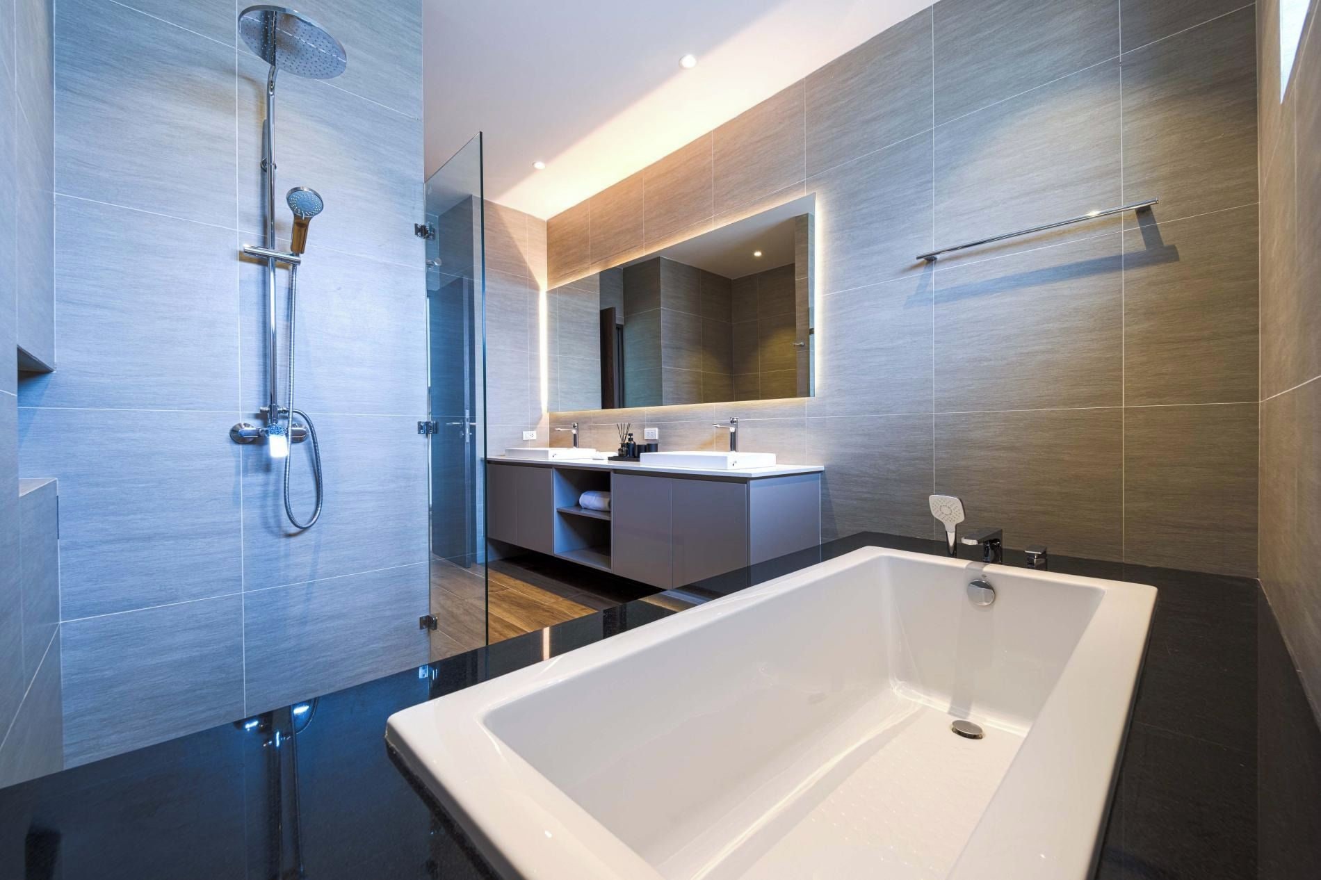 Une salle de bain moderne avec une grande baignoire, une douche à parois de verre et un meuble-lavabo avec un miroir.