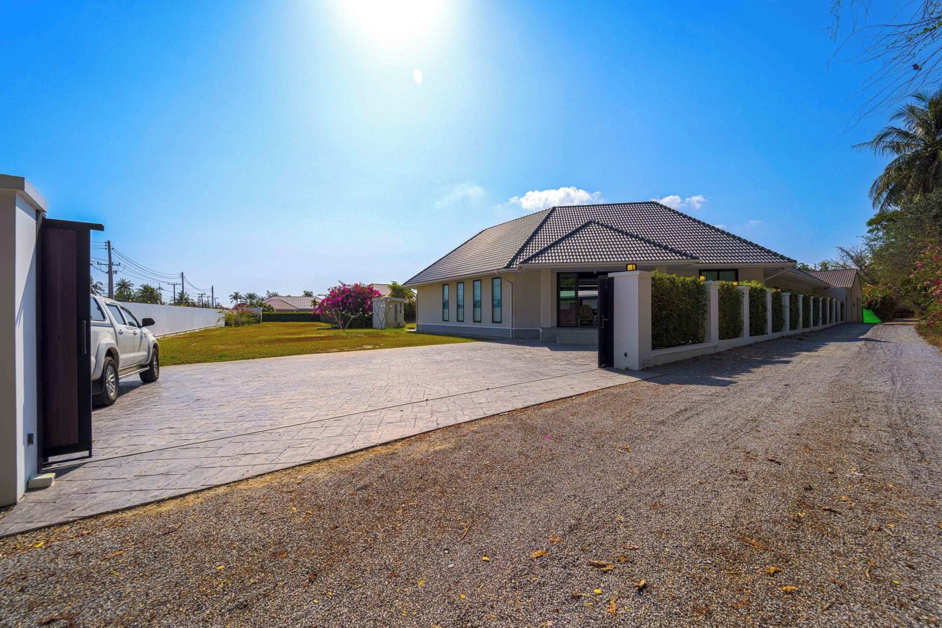 A modern building with a covered entrance, paved driveway, and a parked car.