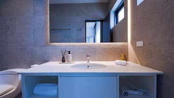 A modern bathroom with a large vanity, a mirror, and a window.