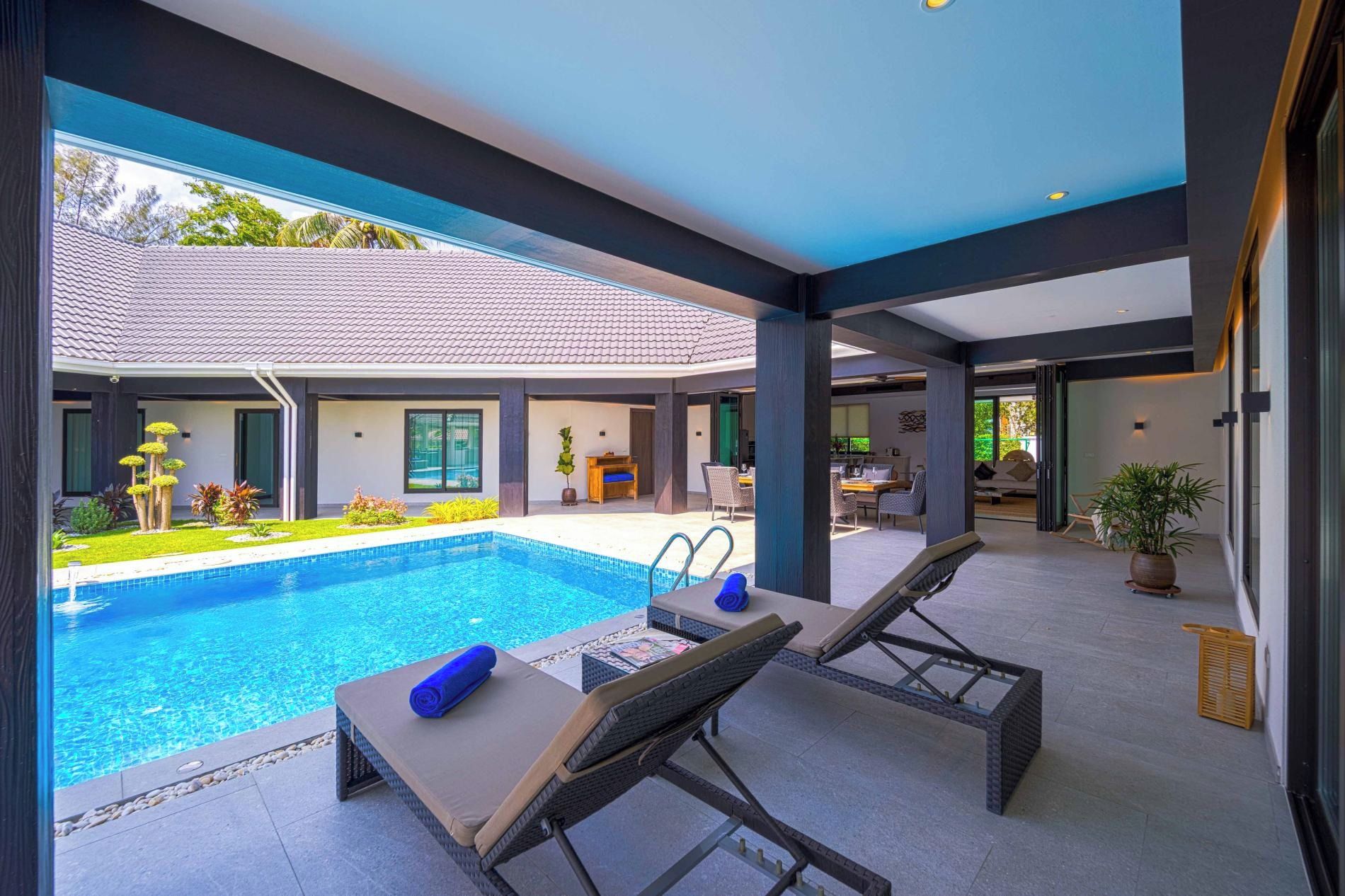 A modern pool area with lounge chairs and a clear view of the surrounding landscape.