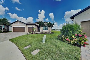 A residential area with houses, a well-maintained lawn, and a clear sky. - The Nomeblla Oasis (Fort Myers)