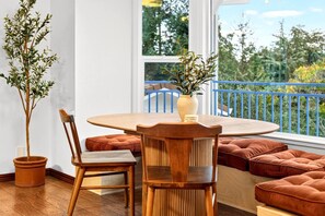 A dining area with a round table, wooden chairs, and a potted plant. - HillCreek Villa - Spa • Sauna • Cold Plunge • Creekside Shower • Arcade Games (Redding)