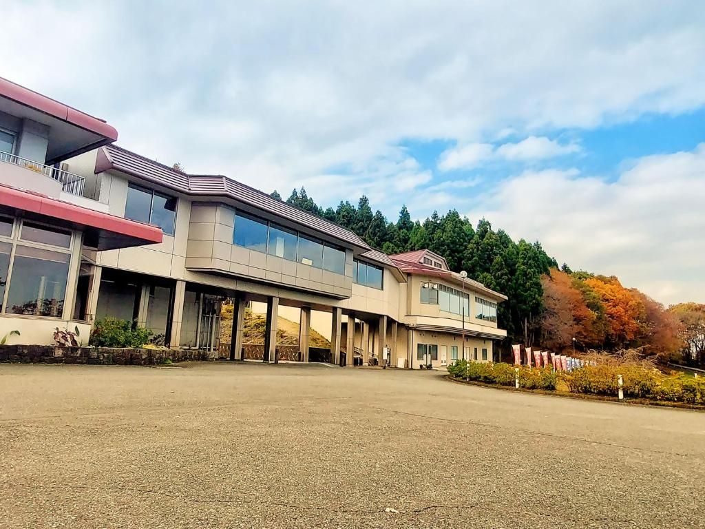 A modern building with a flat roof, large windows, and a covered entrance area.