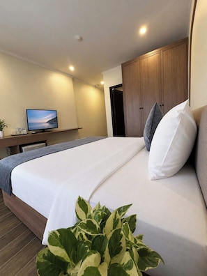 A hotel room with a bed, a television, a desk, and a wardrobe. - Rising Dragon Palace Hotel (Hoan Kiem)