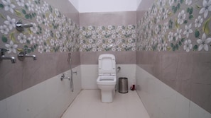 Un baño con inodoro, ducha y secamanos.