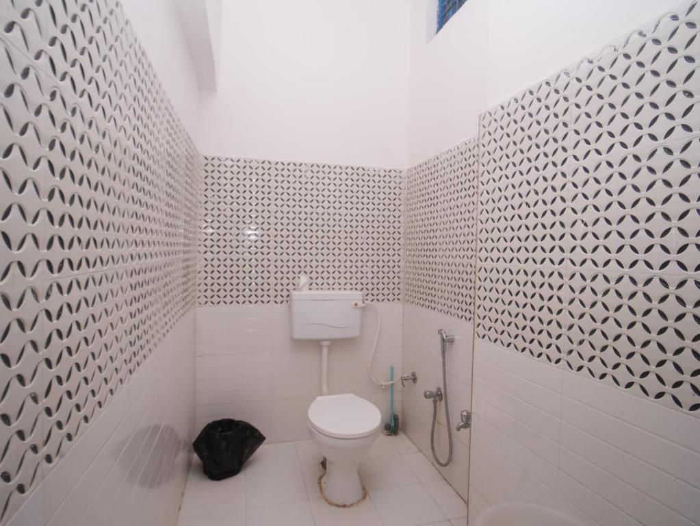 Un baño pequeño con inodoro, lavamanos y ducha.