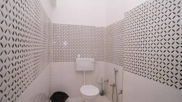 Un baño pequeño con inodoro, lavamanos y ducha.