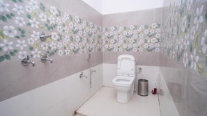 A bathroom with a toilet, shower, and a trash bin. - Himalayan Nest Chopta (Ukhimath)