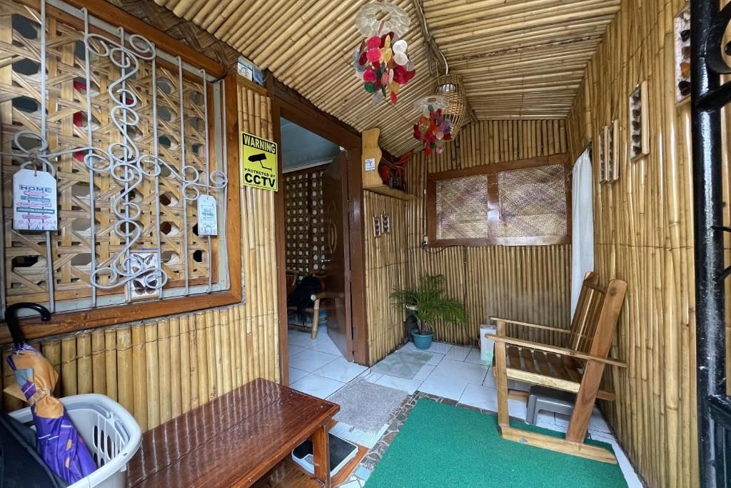 A room with a bamboo wall, a wooden bench, a chair, and a small table.