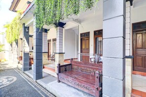 A building with a stone facade, wooden doors, and a bench outside. - Luxury Deluxe DBL Escape W/ Free Wifi and Parking (Kedonganan)