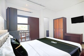 A hotel room with a bed, a desk, a wardrobe, a television, and a balcony. - Luxury Deluxe DBL Escape W/ Free Wifi and Parking (Kedonganan)