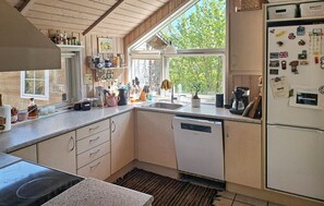 A kitchen with a dishwasher, sink, and various kitchen items on the counter. - Pet friendly home in Frørup with sauna (Frørup)
