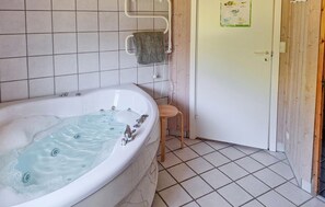 A bathroom with a bathtub, a wooden stool, and a door with a sign. - Pet friendly home in Frørup with sauna (Frørup)