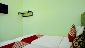 A room with a bed, pillows, a wall-mounted shelf, and a wall clock. - Cozy Twin Escape With Free Wifi and Parking (Parapat)