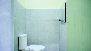 A small, enclosed bathroom with a toilet, a shower area, and a door. - Cozy Twin Escape With Free Wifi and Parking (Parapat)